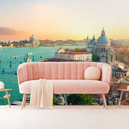 Les canaux, les toits et les édifices de Venise s’étendent sous un ciel aux couleurs chaudes.